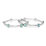 Silver bangles with turquoise clover-shaped stones on a white background