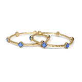 Gold hoop earrings with blue star-shaped stones on a white background