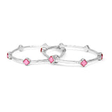 Silver bangles with pink flower-shaped stones on a white background