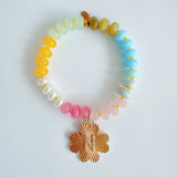 Colorful beaded stretch bracelet featuring a radiant gold-tone clover charm with an engraved initial at the center. The bracelet combines vibrant multicolored beads with a polished gold accent, creating a cheerful and personalized accessory perfect for layering or gifting.