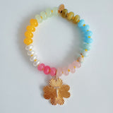 Colorful beaded stretch bracelet featuring a radiant gold-tone clover charm with an engraved initial at the center. The bracelet combines vibrant multicolored beads with a polished gold accent, creating a cheerful and personalized accessory perfect for layering or gifting.