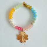 Colorful beaded stretch bracelet featuring a radiant gold-tone clover charm with an engraved initial at the center. The bracelet combines vibrant multicolored beads with a polished gold accent, creating a cheerful and personalized accessory perfect for layering or gifting.