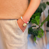 Colorful beaded stretch bracelet featuring a radiant gold-tone clover charm with an engraved initial at the center. The bracelet combines vibrant multicolored beads with a polished gold accent, creating a cheerful and personalized accessory perfect for layering or gifting.