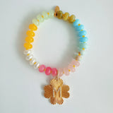 Colorful beaded stretch bracelet featuring a radiant gold-tone clover charm with an engraved initial at the center. The bracelet combines vibrant multicolored beads with a polished gold accent, creating a cheerful and personalized accessory perfect for layering or gifting.