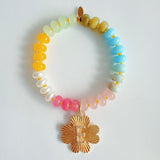 Colorful beaded stretch bracelet featuring a radiant gold-tone clover charm with an engraved initial at the center. The bracelet combines vibrant multicolored beads with a polished gold accent, creating a cheerful and personalized accessory perfect for layering or gifting.