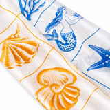 Fabric with mermaid, shell, and starfish patterns on a white background