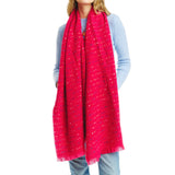 Person wearing a bright red scarf with a subtle pattern on a white background