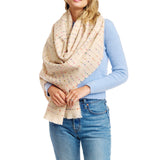 Person wearing a beige polka dot scarf, blue sweater, and jeans on a white background
