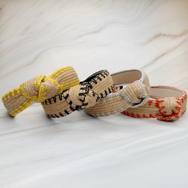 Raffia headband with vibrant color-stitched detail in a knotted design, offering a fun and summery look.