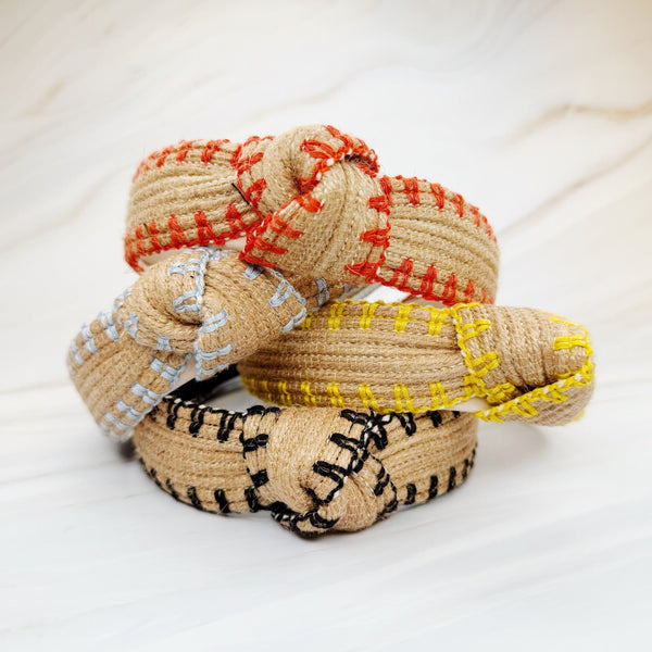 Raffia headband with vibrant color-stitched detail in a knotted design, offering a fun and summery look.