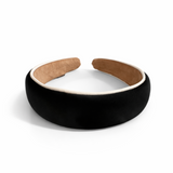 A softly padded wide headband in a solid hue, finished with a distinct contrast border trim along the edges, offering a chic and polished look for everyday wear.