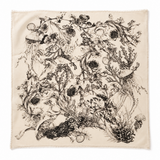 A square cream-colored scarf with fringed edges, featuring a detailed black ink illustration of sea life including a seal, jellyfish, and kelp.