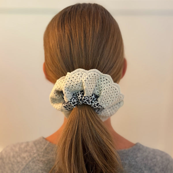 Stylish hair scrunchie featuring a bold cheetah print with delicate crochet trim, blending wild flair with a touch of handcrafted charm.