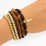 Stack of beaded bracelets on a wrist with a white background