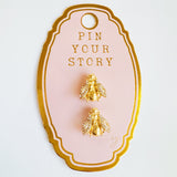 Gold-tone bee-shaped brooch or earrings with sparkling crystal-encrusted wings and a textured body, designed as a magnetic pin set for styling scarves or garments; comes in a set of two.