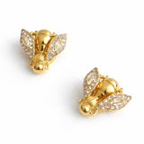 Gold-tone bee-shaped brooch or earrings with sparkling crystal-encrusted wings and a textured body, designed as a magnetic pin set for styling scarves or garments; comes in a set of two.