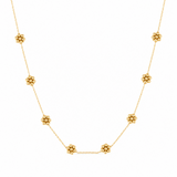 Gold necklace with small beads on a white background