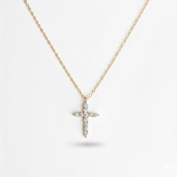 Delicate cross pendant necklace featuring shimmering cubic zirconia accents on a fine gold-tone chain, offering a subtle yet radiant touch for everyday elegance.