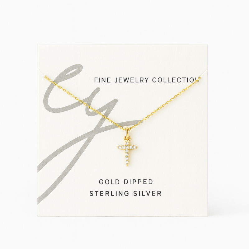 Delicate cross pendant necklace featuring shimmering cubic zirconia accents on a fine gold-tone chain, offering a subtle yet radiant touch for everyday elegance.