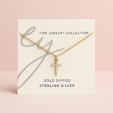 Delicate cross pendant necklace featuring shimmering cubic zirconia accents on a fine gold-tone chain, offering a subtle yet radiant touch for everyday elegance.