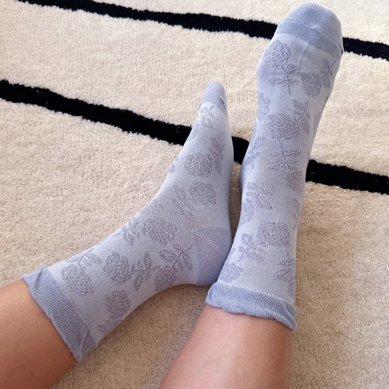 Set of two soft knit socks featuring an embossed flower pattern throughout, offering cozy texture and a subtle floral detail for everyday comfort with a delicate twist.