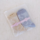 Set of two soft knit socks featuring an embossed flower pattern throughout, offering cozy texture and a subtle floral detail for everyday comfort with a delicate twist.