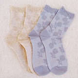 Set of two soft knit socks featuring an embossed flower pattern throughout, offering cozy texture and a subtle floral detail for everyday comfort with a delicate twist.