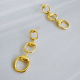 Gold-tone drop earrings featuring three interlocking links inspired by classic horse bit and equestrian motifs. The polished finish and articulated structure create elegant movement and a refined, timeless statement style.