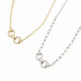 Two gold and silver necklaces with horsebit clasps on a white background