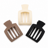 Three silicone sanding sponges in beige, brown, and black on a white background