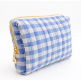 Gingham quilted cosmetic case in blue with gold daisy zipper pull in white background