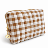 Gingham quilted cosmetic case in light brown with gold daisy zipper pull in white background