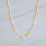 Gold-tone chain necklace featuring a mix of small polished pearls and irregular freshwater-style pearls, finished with an adjustable clasp closure.