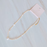 Gold-tone chain necklace featuring a mix of small polished pearls and irregular freshwater-style pearls, finished with an adjustable clasp closure.