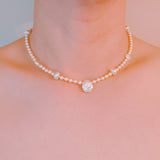 Gold-tone chain necklace featuring a mix of small polished pearls and irregular freshwater-style pearls, finished with an adjustable clasp closure.