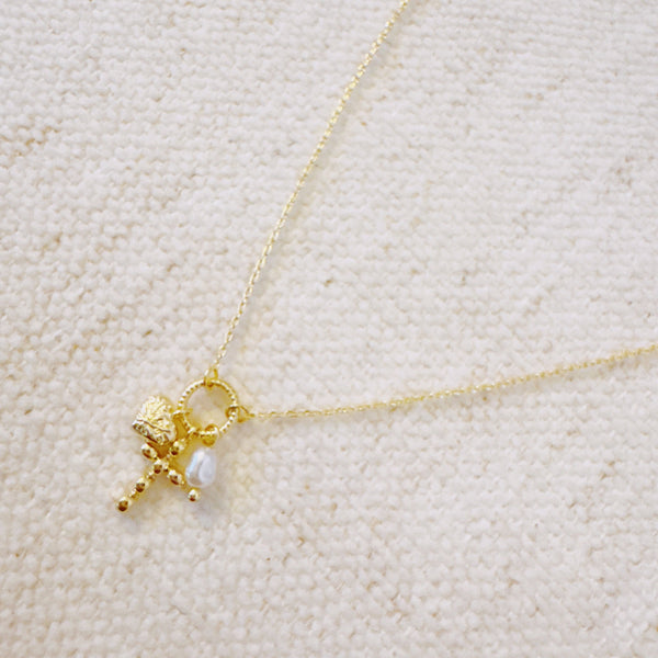 Gold-tone chain necklace with a charming cluster of a heart, cross, and pearl, perfect for layering or adding a touch of faith and love to any outfit.