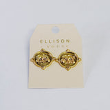 Gold round stud earrings featuring a raised fleur-de-lis design on a coin-style medallion with decorative beaded edges.