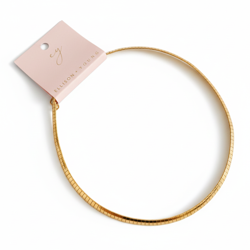 Gold-tone modern herringbone necklace featuring a sleek, flat chain design with subtle reflective shine and a secure clasp closure