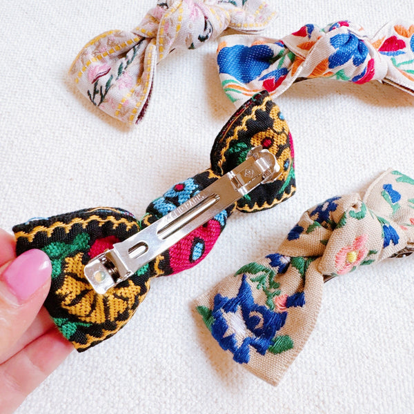 Elegant hair clip featuring intricate French floral embroidery on a soft fabric base—offering a timeless, romantic accent to any hairstyle.