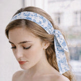 Woman wearing a blue floral headband with a blurred background