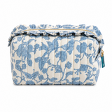 a blue floral toile print cosmetic case with ruffle details on top around gold zipper, white background