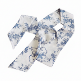 Elegant and versatile long silk hair scarf featuring a classic French toile pattern. The French Toile Sleek and Long Hair Scarf adds a touch of Parisian charm, perfect for tying around a ponytail, wrapping around a bun, or styling as a headband.