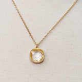 Gold chain necklace featuring a cushion-cut clear crystal pendant with a textured gold bezel, radiating timeless shine and elegance.