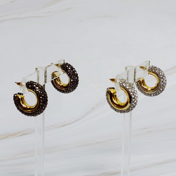 A pair of gold-tone hoop earrings adorned with shimmering rhinestones
