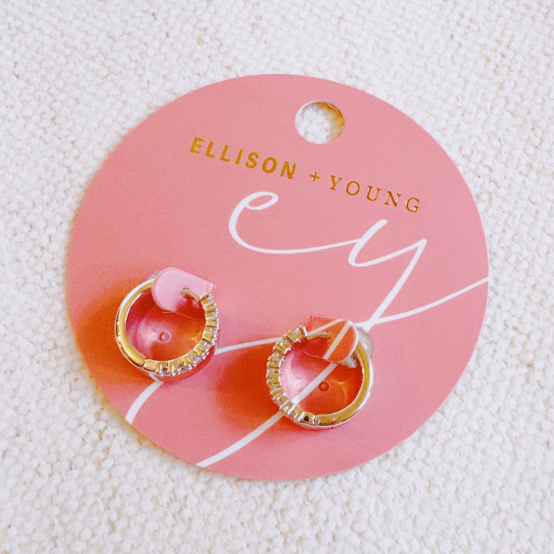 Contoured silver-tone huggie earrings featuring a sleek sculpted shape with a subtle strip of sparkling stones along one edge for a hint of glam.