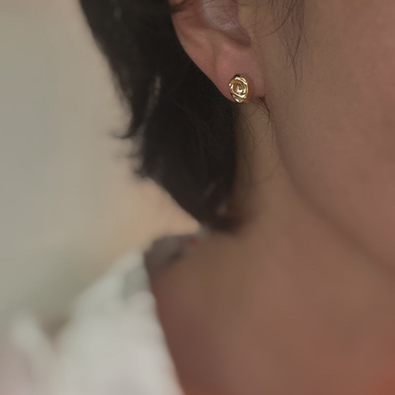 Gold-tone dome stud earrings with a smooth, pebble-like shape and a polished finish for a modern, minimalist look.