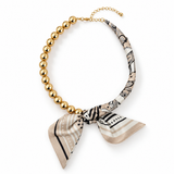 Golden Bead Scarf-Tie Necklace in Beige – gold-tone bead strand with beige, black and cream printed scarf wrap and bow tie, lobster clasp and extender