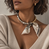 Model wearing the Golden Bead Scarf-Tie Necklace in Beige with a cream V-neck sweater