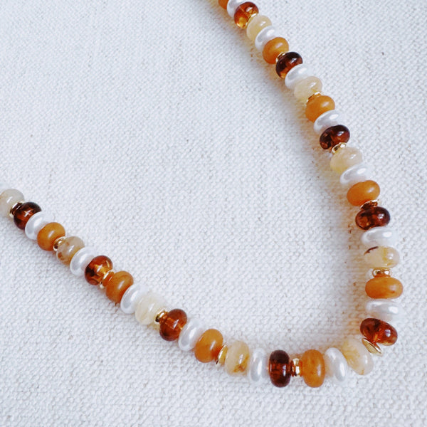 Beaded necklace featuring a blend of golden, amber, and brown-toned beads with subtle shimmer and natural variation, creating an earthy yet refined look.