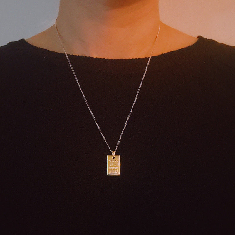 Elegant two-tone necklace featuring a sleek rectangular gold bar pendant on a silver-metal chain, blending modern edge with classic shine